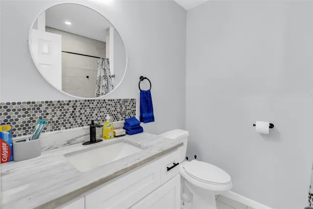 a bathroom with a sink mirror vanity and toilet