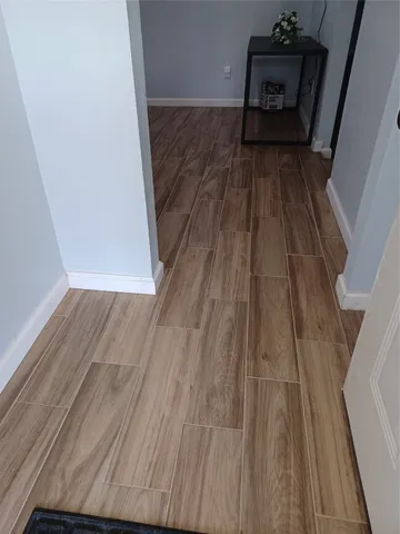 a view of a hallway in a house with wooden floor