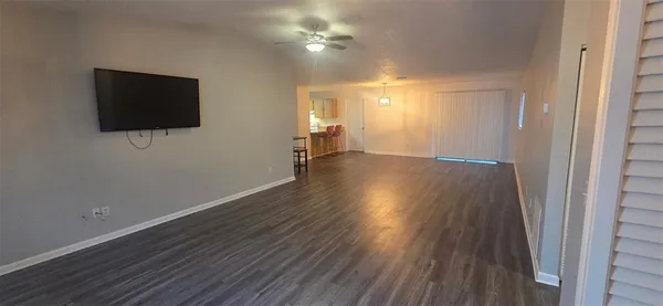 a view of a livingroom with wooden floor and a flat screen tv