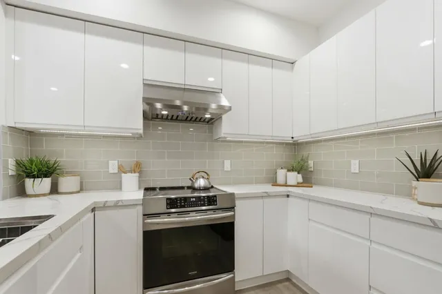 a kitchen with stainless steel appliances granite countertop a sink a stove and cabinets