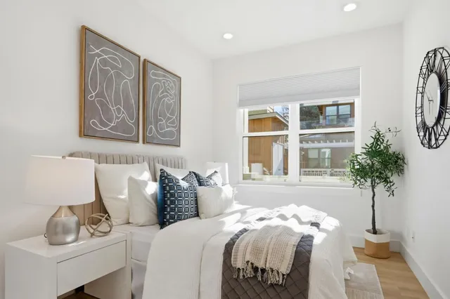 a bedroom with bed and a potted plant