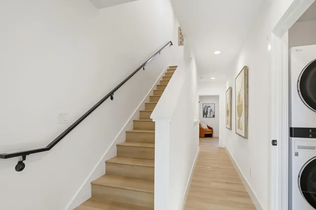 a view of a hallway with wooden floor and staircase