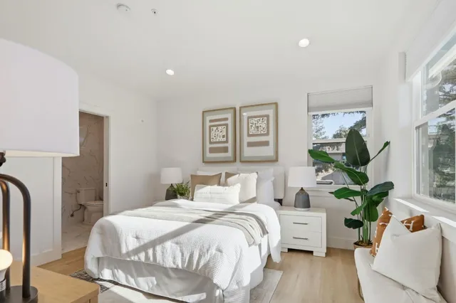 a bedroom with a bed mirror and window