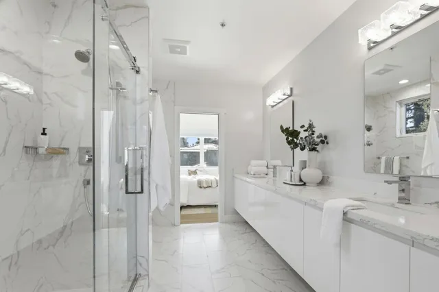 a bathroom with a double vanity sink mirror and shower