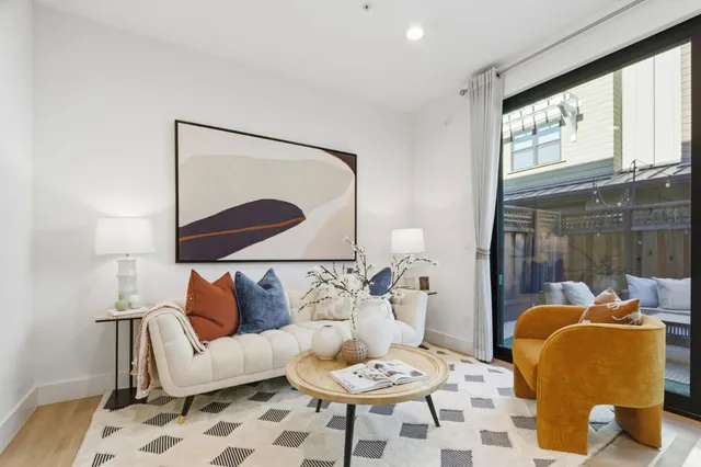 a living room with furniture and a painting on the wall