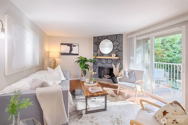 a living room with furniture a fireplace and a floor to ceiling window