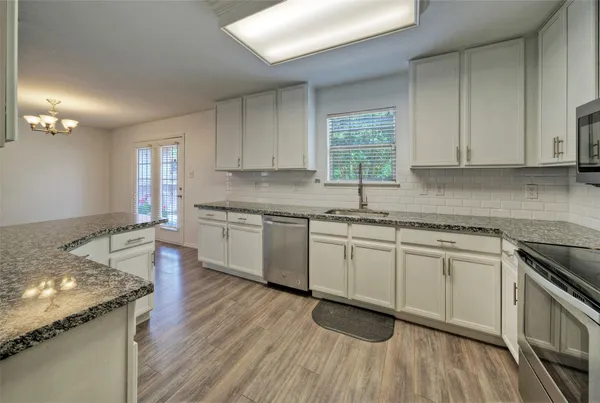 a kitchen with granite countertop white cabinets and white appliances
