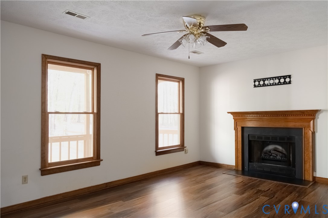 2477 Calno Road Hanover, VA 23069 - Photo 6 of 33 a view of an empty room with wooden floor a fireplace and a window