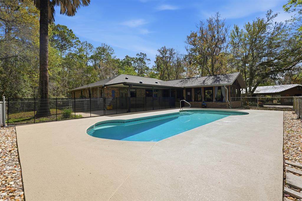 158 Cone Road Ormond Beach, FL 32174 - Photo 2 of 40 a view of swimming pool and trees in the background