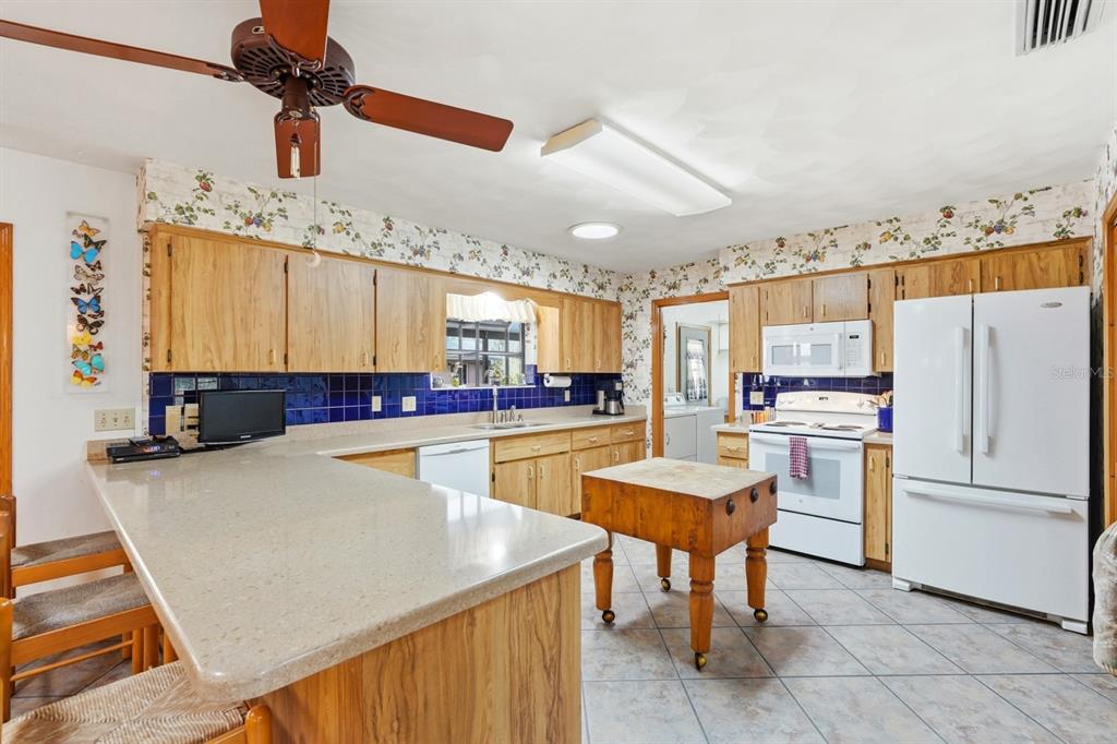158 Cone Road Ormond Beach, FL 32174 - Photo 5 of 40 a large kitchen with a table chairs refrigerator and a window