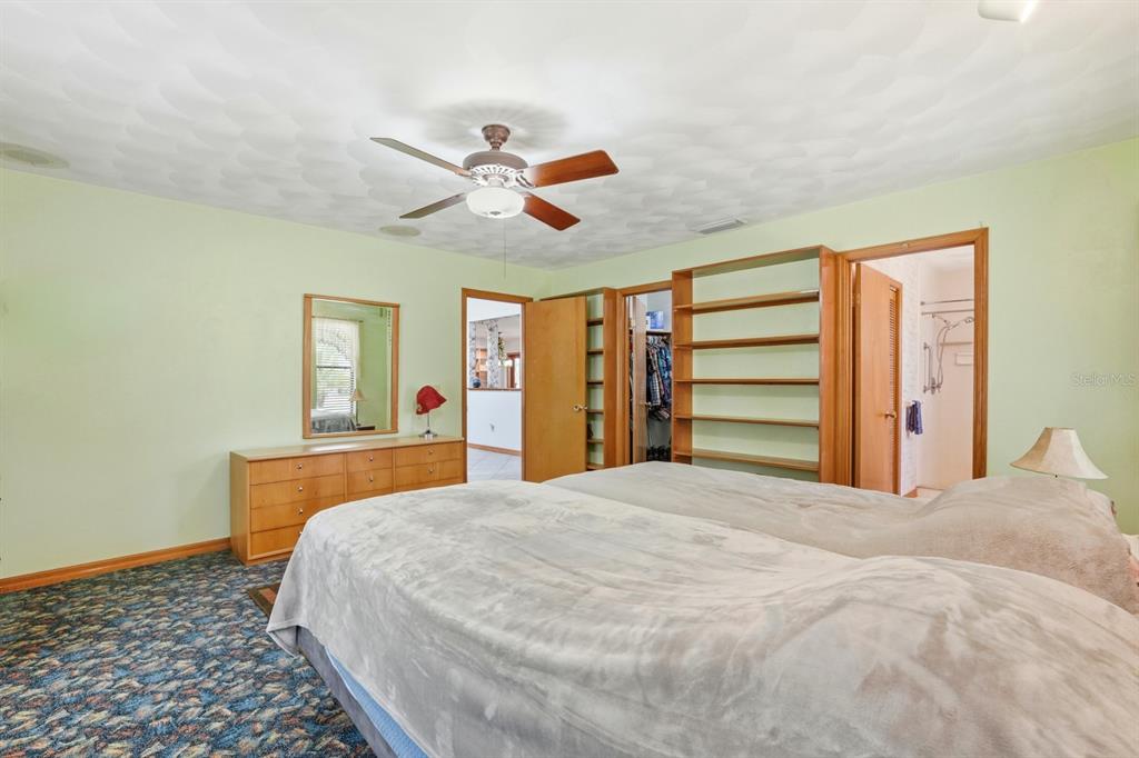 158 Cone Road Ormond Beach, FL 32174 - Photo 9 of 40 a bedroom with a large bed and a chandelier