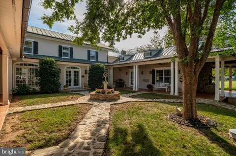 a view of a house with backyard and sitting area