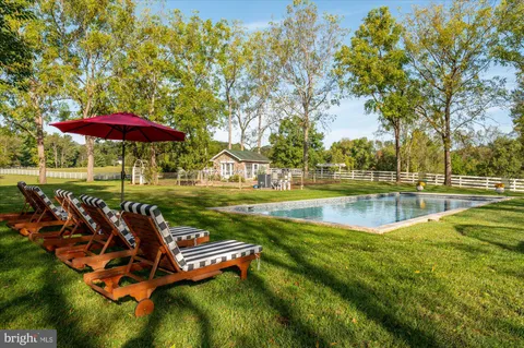 a big yard with lots of green space and trees in the background