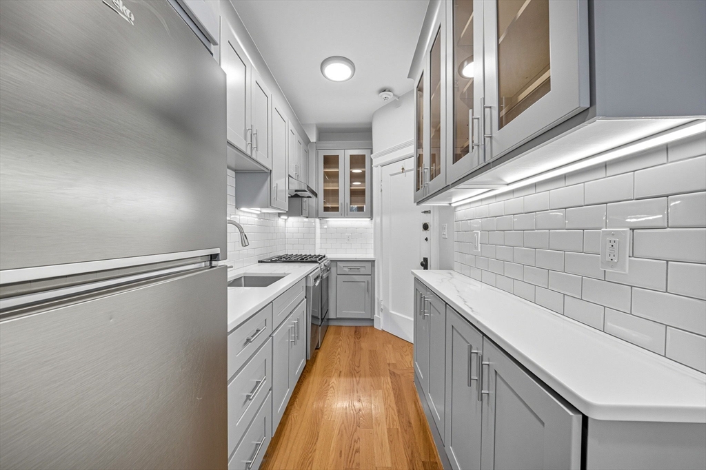 4 Crawford Street, Unit U4 Cambridge, MA 02139 - Photo 9 of 22 a kitchen with cabinets and wooden floor