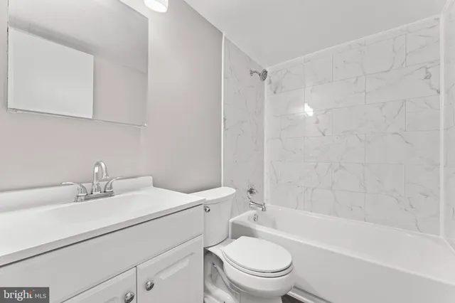 a bathroom with a sink toilet vanity and shower