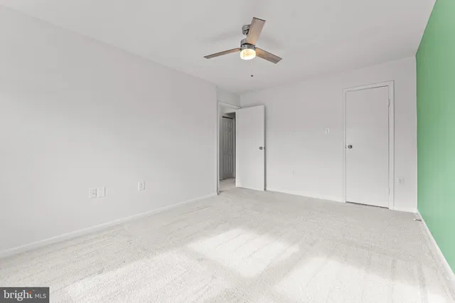 a view of an empty room with a chandelier fan