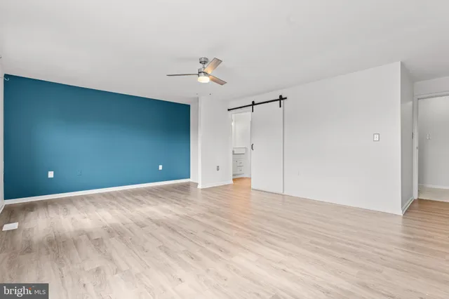 a view of an empty room with wooden floor