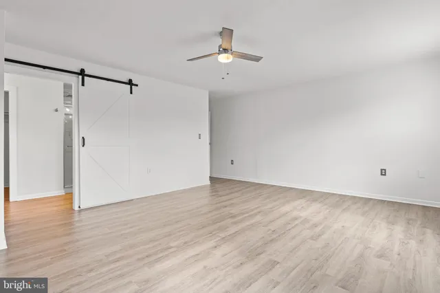 a view of an empty room with wooden floor