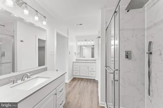 a bathroom with a granite countertop sink mirror and shower