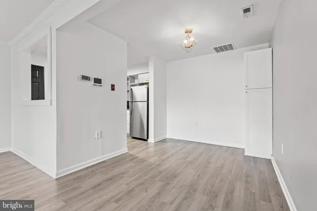 a view of an empty room with closet and a window