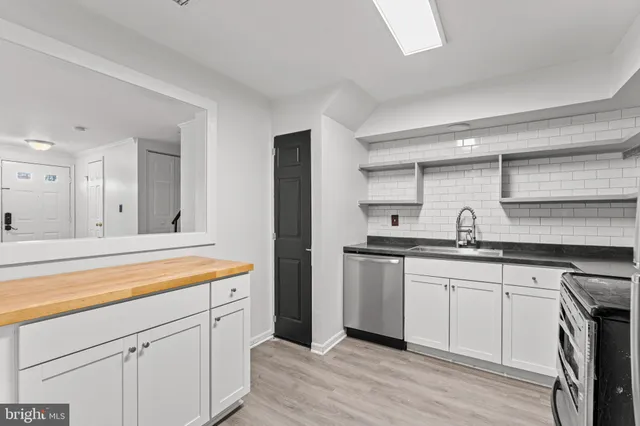 a kitchen with stainless steel appliances granite countertop white cabinets sink and stove