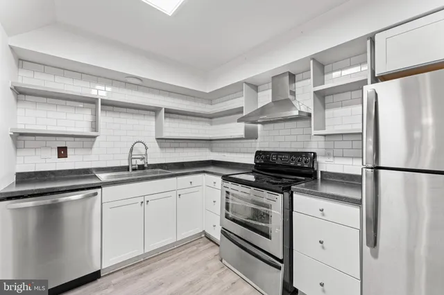 a kitchen with appliances a sink and cabinets