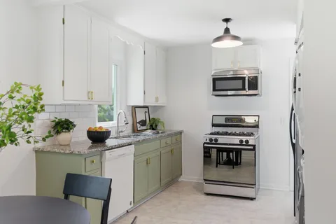 a kitchen with stainless steel appliances granite countertop a sink and a stove