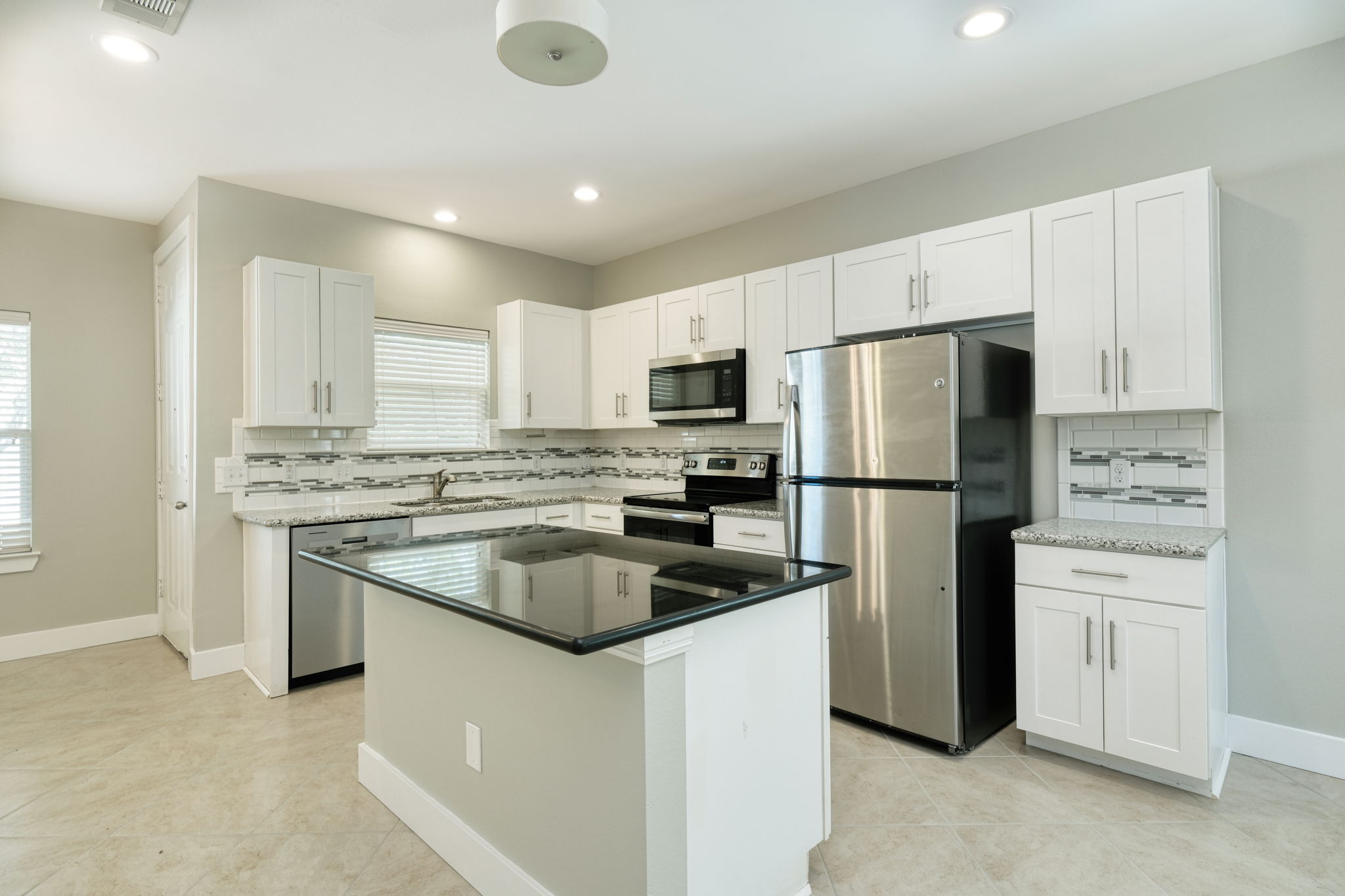 615 Spring Street, Unit 3 Round Rock, TX 78664 - Photo 2 of 14 A well-appointed kitchen features stainless steel appliances and a spacious island.