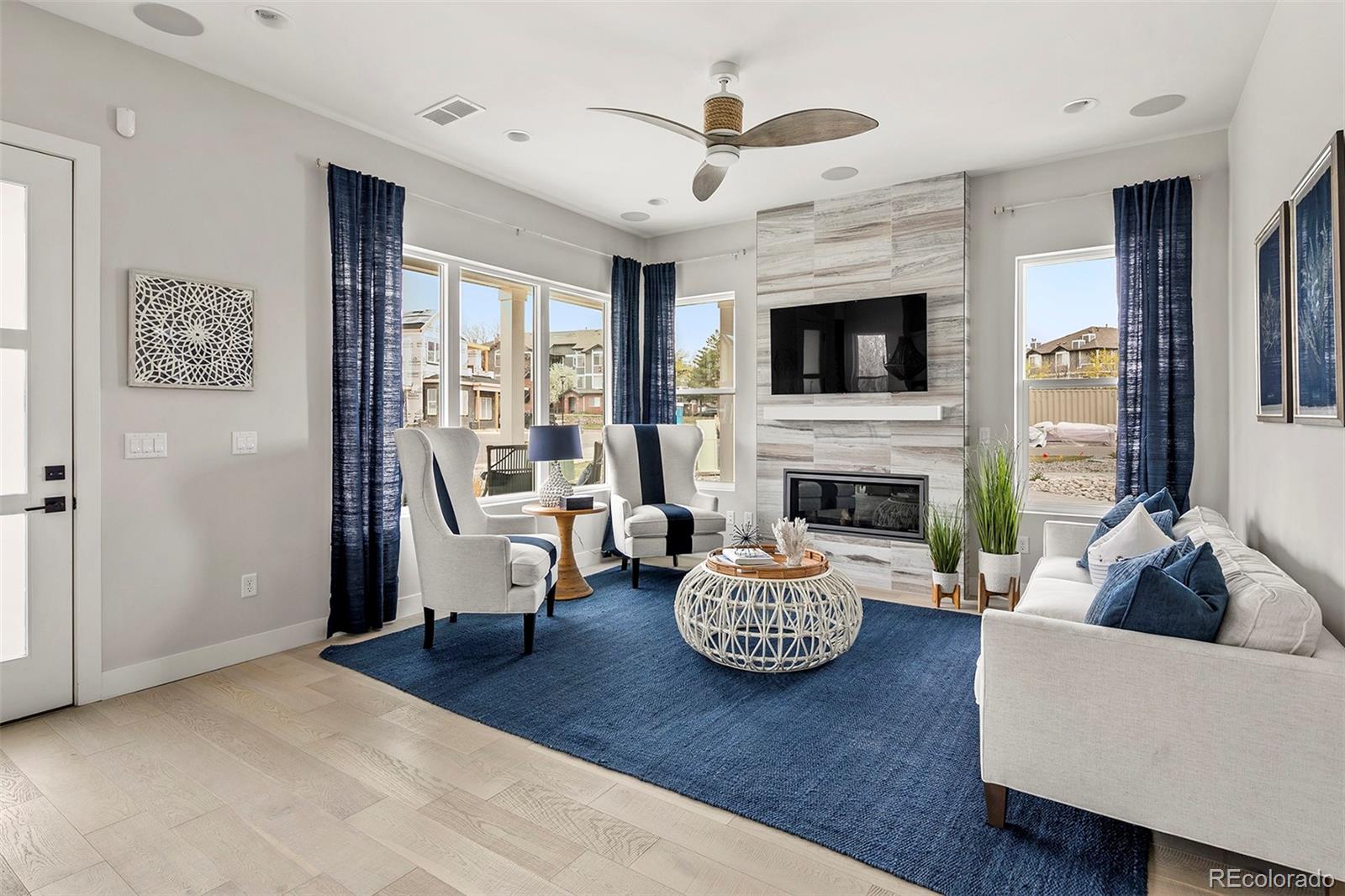 a living room with furniture a flat screen tv and a fireplace