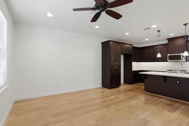 a kitchen with stainless steel appliances kitchen island granite countertop a refrigerator and a sink