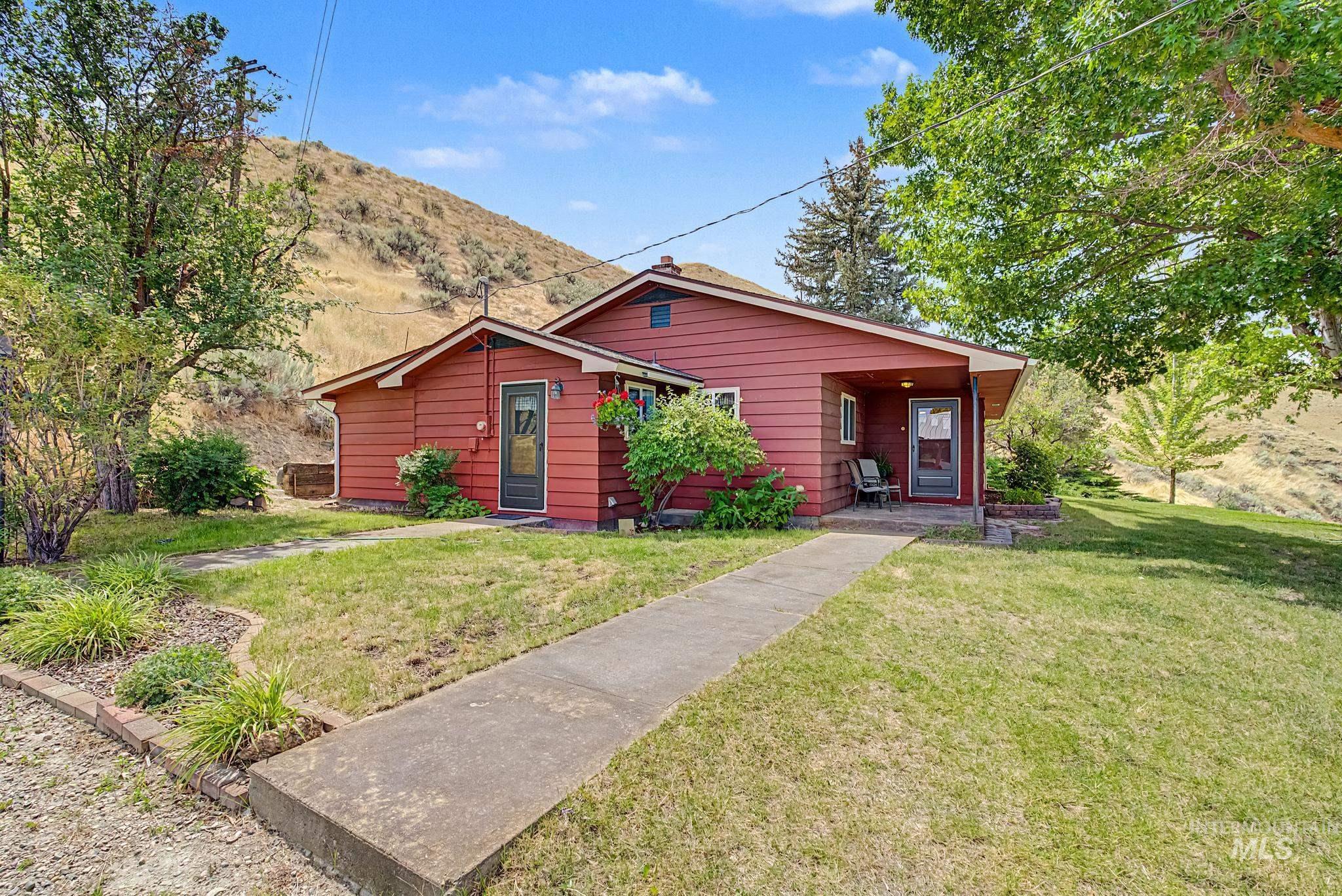 4311 Frozen Dog Road Emmett, ID 83617 - Photo 4 of 31 Red siding exterior with a covered front porch and concrete walkway