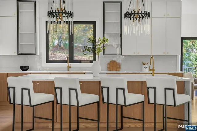 a white kitchen with a table chairs and a window