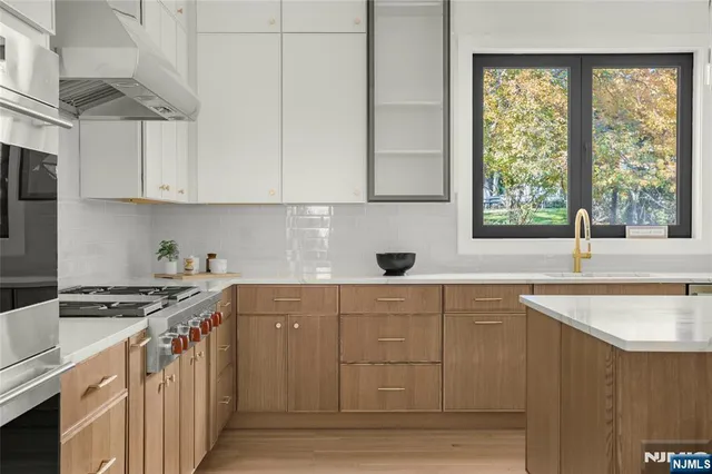 a kitchen with stainless steel appliances granite countertop a sink stove and cabinets