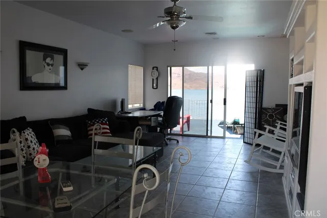a living room with furniture a chandelier and a floor to ceiling window