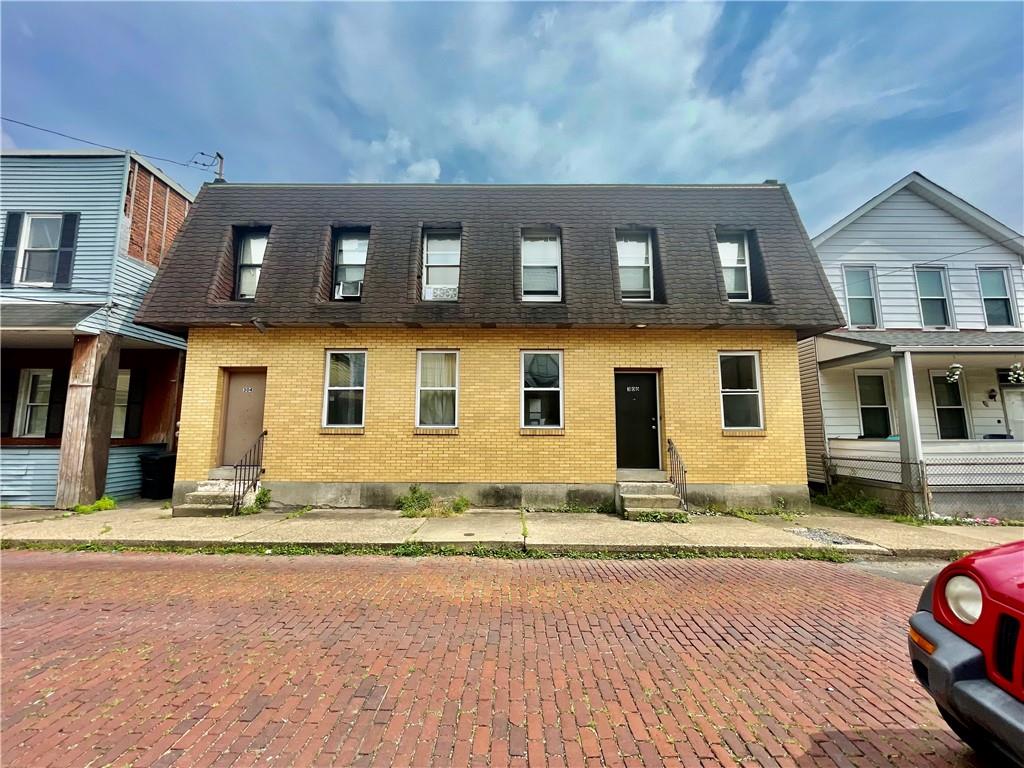 a view of a brick house with many windows