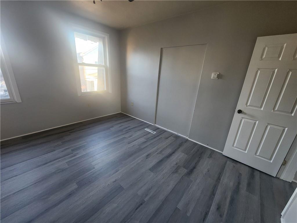 306 Campbell Street McKees Rocks, PA 15136 - Photo 16 of 28 an empty room with wooden floor and windows