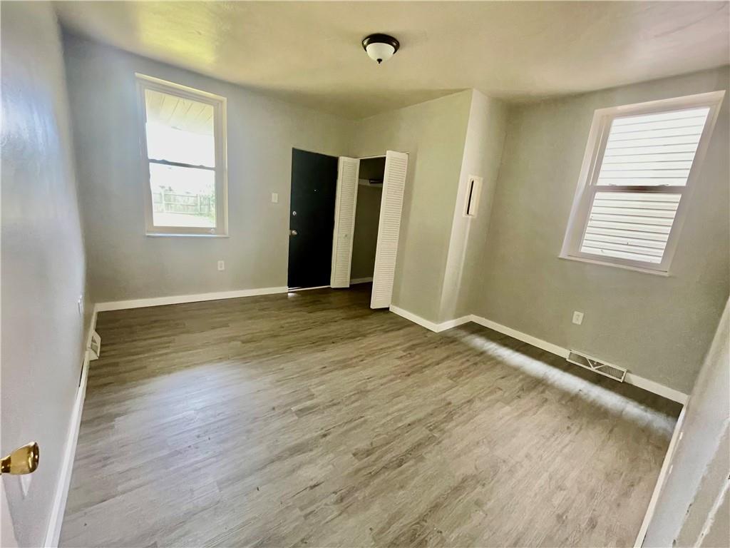 306 Campbell Street McKees Rocks, PA 15136 - Photo 18 of 28 an empty room with wooden floor and windows