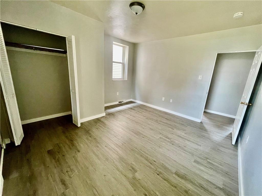 306 Campbell Street McKees Rocks, PA 15136 - Photo 19 of 28 an empty room with wooden floor and windows