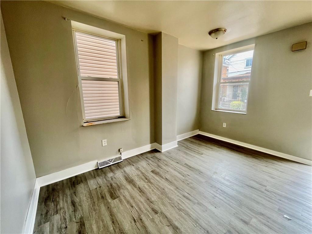 306 Campbell Street McKees Rocks, PA 15136 - Photo 22 of 28 a view of an empty room with wooden floor and a window