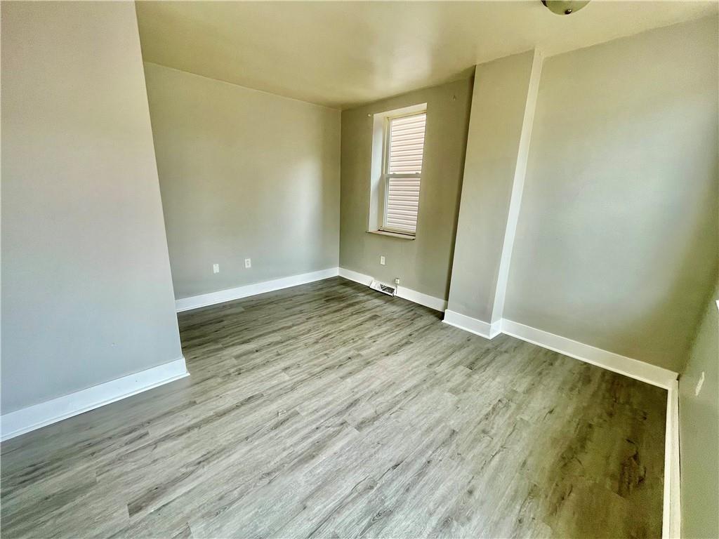 306 Campbell Street McKees Rocks, PA 15136 - Photo 23 of 28 an empty room with wooden floor and windows