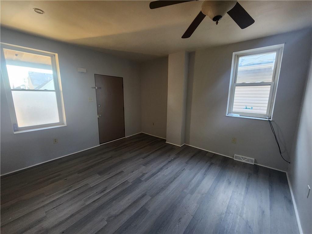 306 Campbell Street McKees Rocks, PA 15136 - Photo 3 of 28 an empty room with wooden floor cabinet and windows