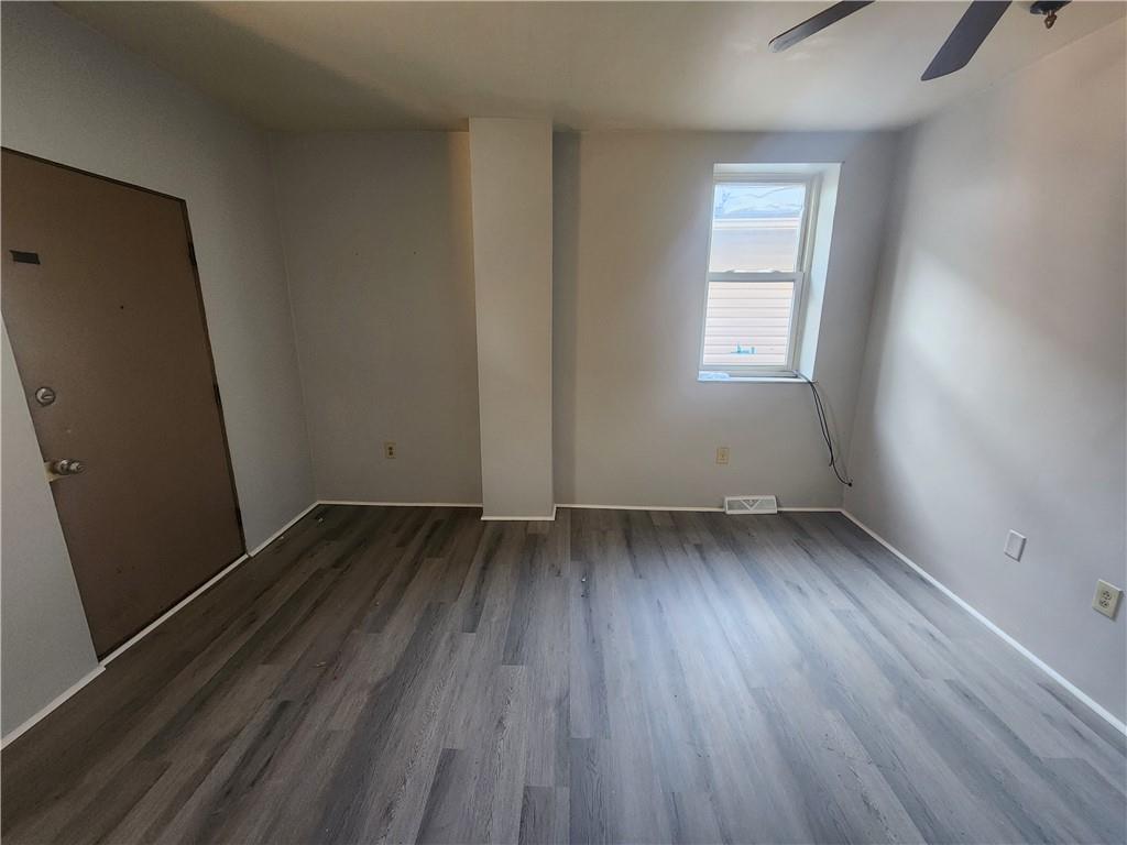 306 Campbell Street McKees Rocks, PA 15136 - Photo 4 of 28 an empty room with wooden floor and windows