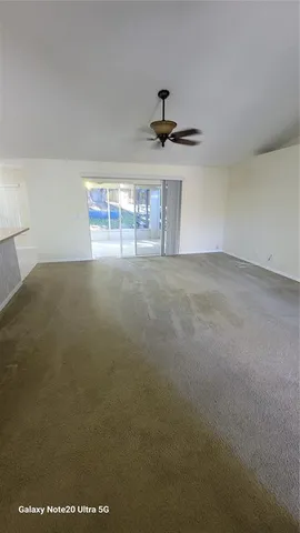 a view of an empty room and chandelier fan