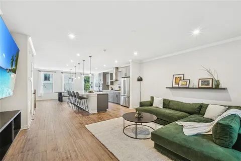a kitchen with stainless steel appliances kitchen island granite countertop a refrigerator and a stove top oven