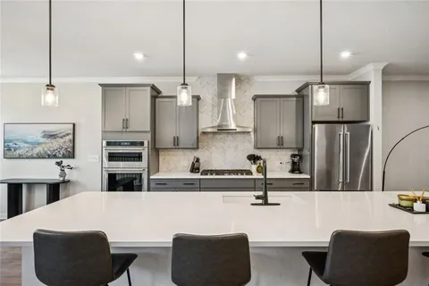a kitchen with stainless steel appliances kitchen island granite countertop a table chairs and a refrigerator