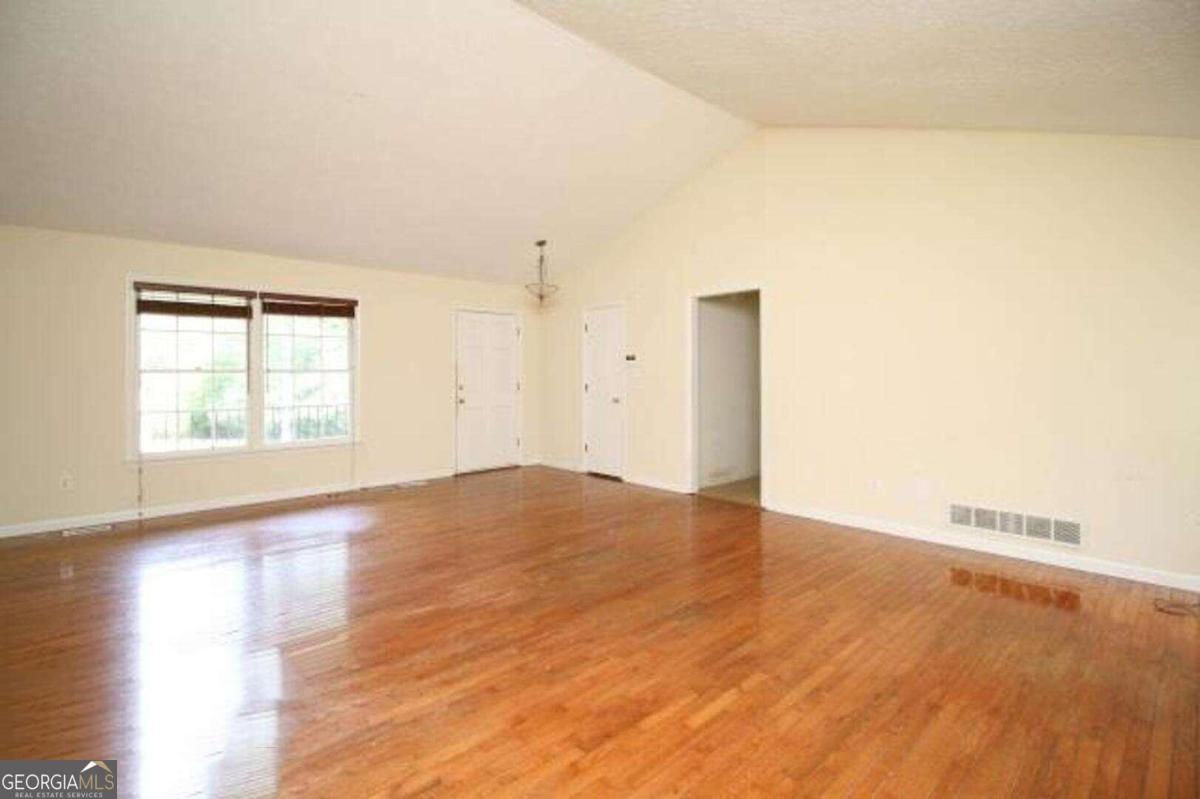 220 Providence Road Athens, GA 30606 - Photo 8 of 15 an empty room with wooden floor and windows