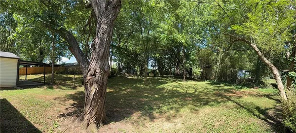 a backyard of a house with swimming pool and trees