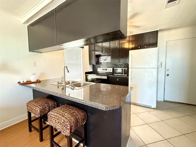 a kitchen with kitchen island a sink stove and refrigerator