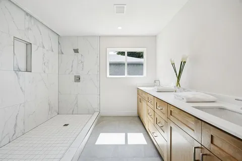 a bathroom with a granite countertop sink a toilet and shower