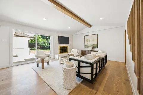 a living room with furniture wooden floor and a large window